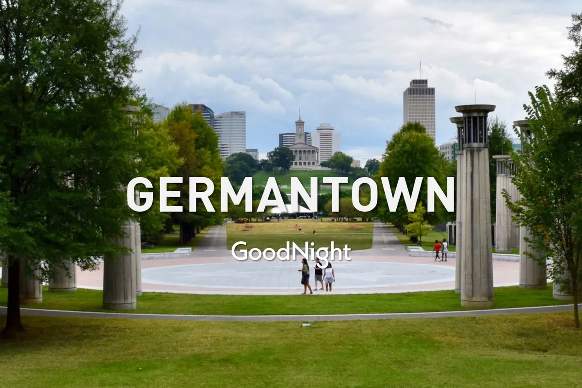 A serene green park stretches out in the foreground, dotted with lush trees and winding pathways. The city skyline rises in the background, blending urban excitement with natural tranquility. The scene suggests a perfect spot for peaceful strolls, quiet conversations, or picnics, all within easy reach of downtown Nashville.
