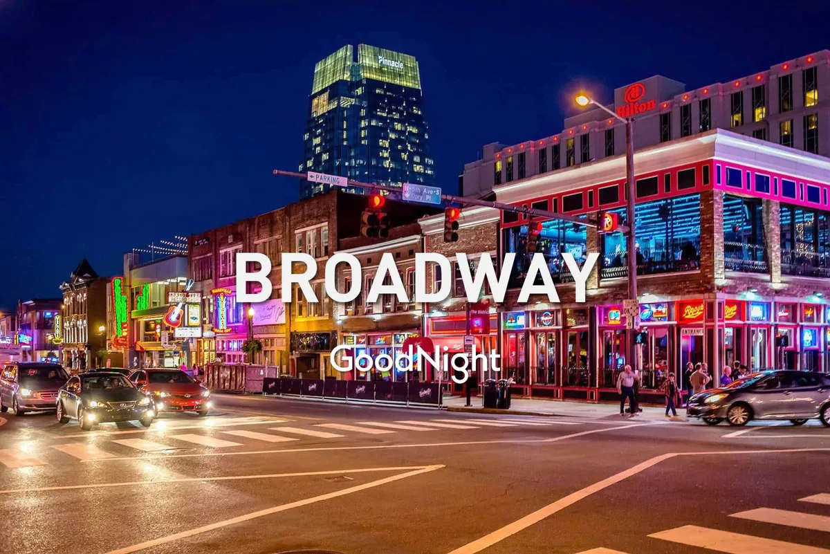 A lively Nashville street scene featuring neon signs, bustling sidewalks filled with people, and busy traffic. The vibrant lights and signage hint at a nightlife and live music scene, capturing the city's energetic spirit after dark.