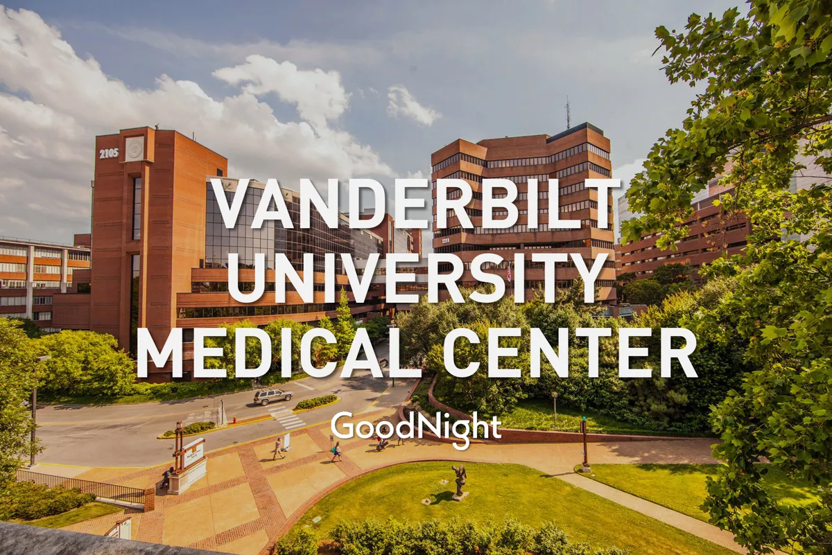 The exterior of Vanderbilt University Medical Center, surrounded by landscaped green areas and pathways. The modern architecture and leafy surroundings convey a sense of prestige and convenience for those needing proximity to major medical or university institutions.
